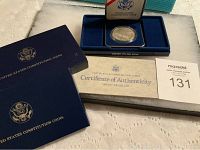 Full lot display including blue presentation case, certificate of authenticity, and auction lot number card.