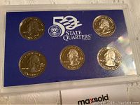 Front view of one holder containing 5 United States Mint state quarters proof coins with clear plastic case and blue background card