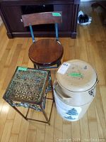 Photo of all three items together on hardwood floor: painted milk can, wooden and metal stool, metal plant stand