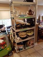 Photo showing the full five shelf metal shelving unit with various items placed on shelves.