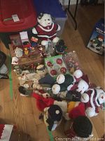 Overview of the Christmas decor including bears, nativity ornaments, and boxed red baubles on wooden floor.