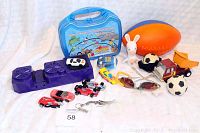 All toys spread out showing Hot Wheels Power Booster, toy cars, soft football, small toys and a blue case