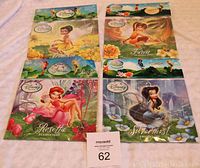 Four Disney Fairies necklaces still sealed on backing cards, including Tinker Bell, Fawn, Rosetta, Silvermist.