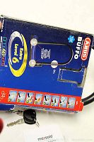 Blue and red original ABUS Buffo lock box highlighting Extra Level 6 security rating, next to set of two keys and the U-lock portion of the bike lock.