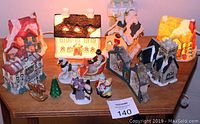 Overall view of all ten pieces in the Christmas village set on a wooden table.