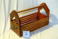 Front angled view of wooden basket showing handle and slatted sides.