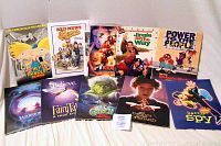 Wide shot of all 10 children's/family movie press kits showing front covers with titles and artwork.