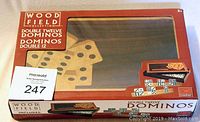 Top view of the unopened product box showing the wooden domino set with double twelve tiles and wooden storage case inside clear plastic window.