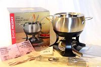 Photo of the fondue set assembled with pot, stand, burner, forks, and original box