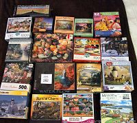 Photo showing an assortment of jigsaw puzzles with various piece counts from 200 to 1000 pieces, including two EZ Make puzzles with larger pieces.