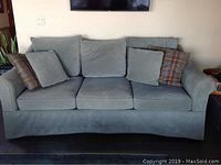 Front view of 3-seat sofa with seat and back cushions and plaid and matching accent pillows