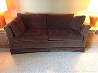 Front view of chocolate brown textured weave fabric sleeper sofa with cushions and skirted base.