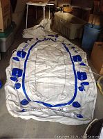 Photo of deflated Sea Eagle inflatable boat laid out on floor showing size and design with blue reinforcement areas.