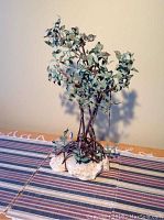 Full front view of the copper tree sculpture displaying trunk, branches and stone base