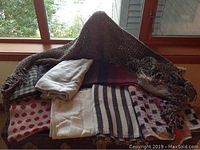 Brown knit scarf with loose weave draped over other scarves