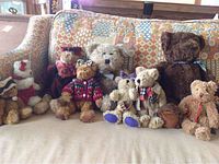 Wide shot showing all the plush figures arranged together on a patterned couch.