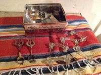 Two metal vintage drawer pulls and eight clear glass drawer pulls on Mexican blanket