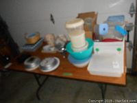 Plastic containers including storage bowls and a large white organizer with colored clips on table