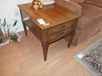 Side view of wood end table showing drawer front and legs.