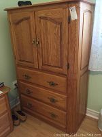 Front view of the Shermag oak highboy showing drawers and doors with brass hardware