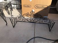 Metal cornice shelf and over-the-door metal decor showing scrollwork.