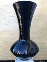 Front view of a tall black amethyst vase with smooth glossy surface and bulbous base.