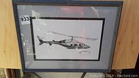Framed black and white lithograph of a Bell 222 helicopter, viewed straight on showing the entire artwork including frame and matting.