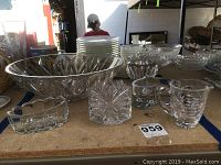 Overview of crystal bowl, heart-shaped piece, teacup, and small containers arranged on a table.