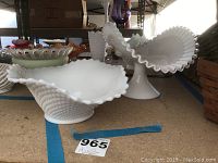 Fenton crest banana boat with ruffled edge and hobnail texture displayed on lower shelf with other glass items nearby