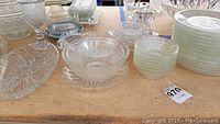 Overview of cut glass dishes, bowls, trays, and goblets with daisy pattern from 1940s, arranged on a table.