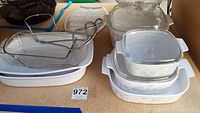 Corningware ceramic bakeware in various shapes including some with blue floral pattern and metal insert