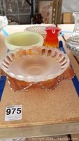 Photo of four vintage glass items including a depression glass bowl, Vaseline glass bowl, vase and weaved style dish