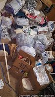 Photo showing large collection of bags and boxes filled with fabric, sewing patterns, and other crafting supplies