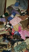 Photo of a large pile of assorted crafting fabrics including patterned and solid fabrics, showing condition and variety.