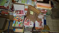Photo of multiple stacked cookbooks of various sizes and covers.