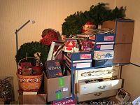 Overall view of top of five boxes with various craft and holiday decoration items including wreaths, baskets, and kits.
