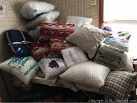 Pile of assorted pillows, pillow inserts, blankets, throws, and bed linens.