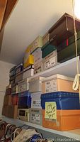 Stacked shoe boxes of various brands including Life Stride, I Love Comfort, Keds, Feather Lite, labeled with sizes and new condition indication.
