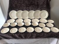 Full set of Johnson Brothers Ironstone dishes including dinner plates, salad plates, bowls, and bread and butter plates displayed against dark cloth.