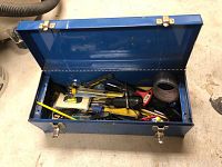 Open blue metal toolbox filled with assorted hand tools including screwdrivers, pliers, and other tools.