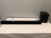 Sanyo sound bar and subwoofer displayed on a table, front view.