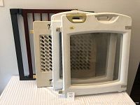 Four baby gates stacked together, showing different designs and materials including wood and plastic.