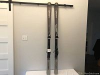 Full view of the two silver Head Cyber X44 skis standing upright.