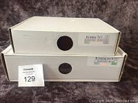 Two white boxes stacked, labeled Kristina 7x7 Burgundy and Kristina 8x10 Burgundy/Black