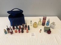 Full lot image showing assorted used nail polish bottles, perfume bottles, and a blue cosmetic bag on a white surface.
