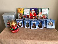 New boxed Coca-Cola Santa musical snow globe, shrinkwrapped Christmas tree ornament sets with Coca-Cola Santa and holiday designs, additional singular boxed ornaments with Christmas themes.