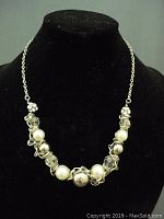 Front view of necklace on black display showing silver-tone chain and bead arrangement