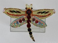 Front view of the vintage dragonfly brooch showing detailed colorful rhinestones on wings and body.
