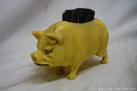 Photo showing front and side view of the small pig-shaped brush with bristles on top