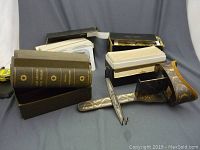 Overall view of two cloth-bound volumes, two boxes of stereoview cards and handheld stereo viewer laid out on fabric background